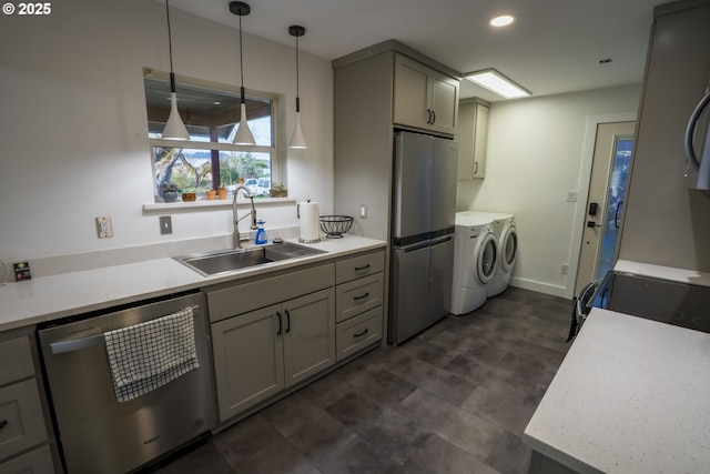 kitchen with gray cabinets, washer and clothes dryer, a sink, stainless steel appliances, and light countertops