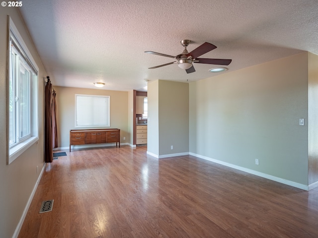 841 NE Kathryn St, Hillsboro, OR 97124 - unfurnished living room with a textured ceiling, a ceiling fan, wood finished floors, and baseboards