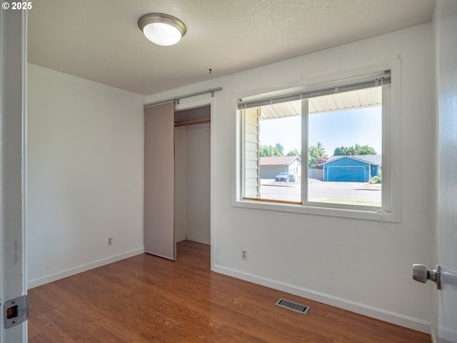 841 NE Kathryn St, Hillsboro, OR 97124 - unfurnished bedroom with wood finished floors, baseboards, multiple windows, and a closet