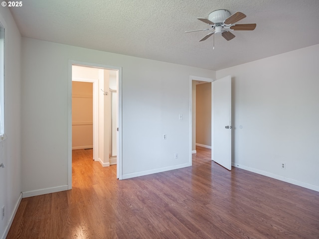 841 NE Kathryn St, Hillsboro, OR 97124 - unfurnished bedroom with wood finished floors, baseboards, a textured ceiling, and a spacious closet