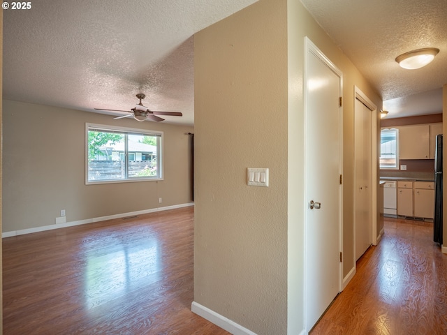 841 NE Kathryn St, Hillsboro, OR 97124 - hallway with a textured ceiling, light wood-style flooring, a textured wall, and baseboards