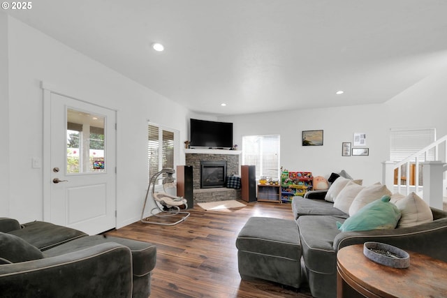 living room with hardwood / wood-style floors, a stone fireplace, and a wealth of natural light