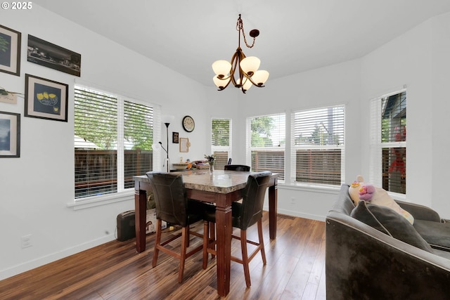 dining space with dark hardwood / wood-style flooring and a notable chandelier