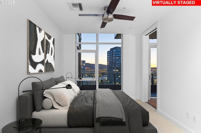 949 NW Overton St Unit 1304, Portland, OR 97209 - bedroom featuring a view of city, a wall of windows, light carpet, and baseboards