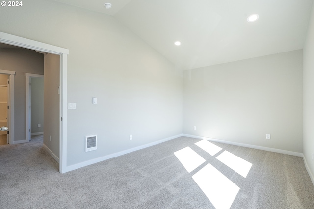 unfurnished room with light carpet and lofted ceiling