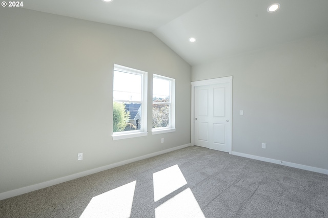 unfurnished room with light carpet and lofted ceiling