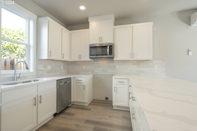 kitchen with decorative backsplash, sink, white cabinets, and stainless steel appliances