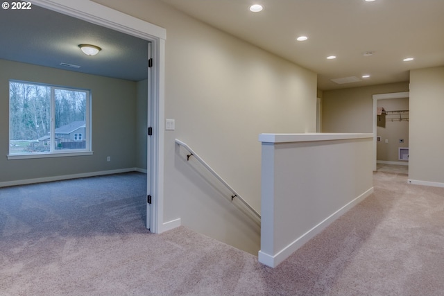 hall with carpet flooring, recessed lighting, baseboards, and an upstairs landing