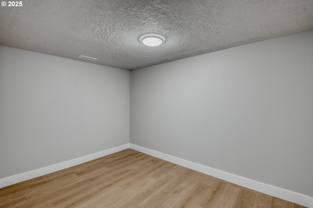 spare room with hardwood / wood-style flooring and a textured ceiling