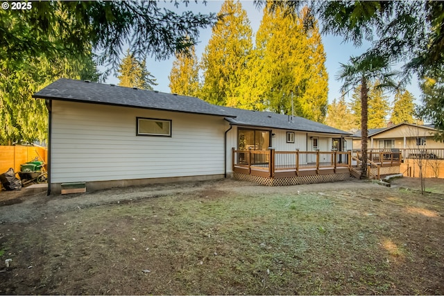 rear view of property with a lawn and a wooden deck