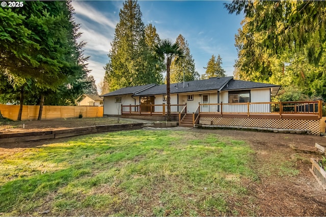 back of house featuring a deck and a lawn