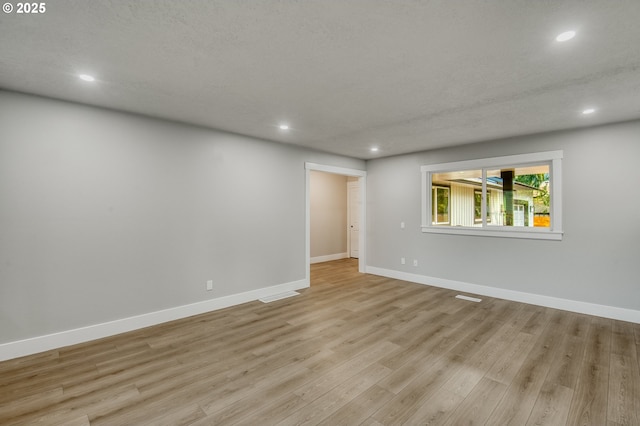 empty room featuring light hardwood / wood-style floors and a textured ceiling