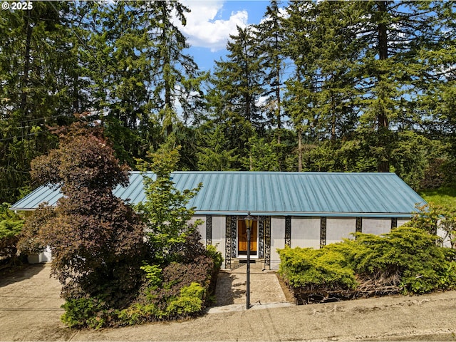 view of front facade featuring metal roof, a standing seam roof, french doors, and stone siding