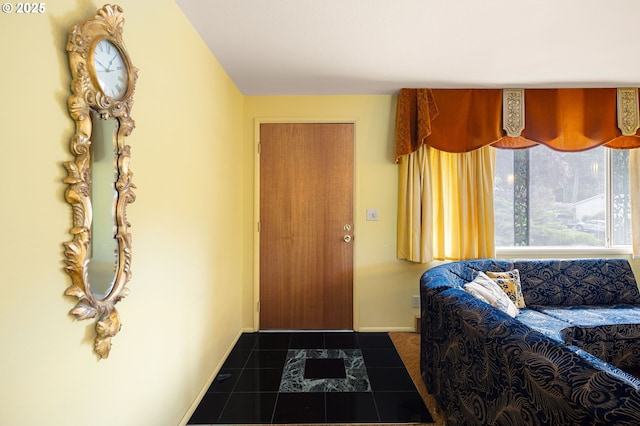 entrance foyer featuring dark tile patterned floors and baseboards