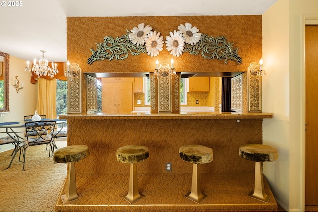 indoor bar featuring a chandelier, healthy amount of natural light, and carpet