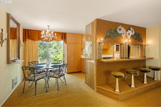 dining room featuring light carpet, a chandelier, and bar