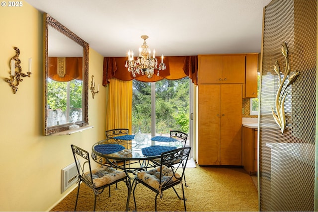 dining space featuring a chandelier, light carpet, and healthy amount of natural light