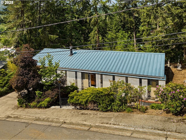 view of front facade featuring metal roof, a standing seam roof, and a gate