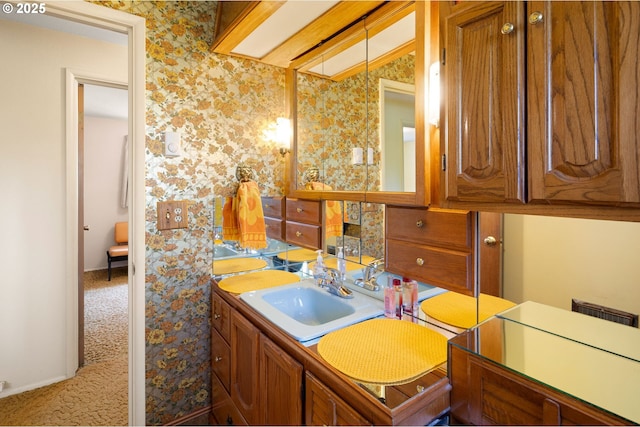 bathroom featuring wallpapered walls and vanity