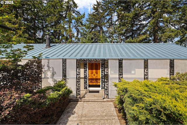 entrance to property featuring a standing seam roof and metal roof