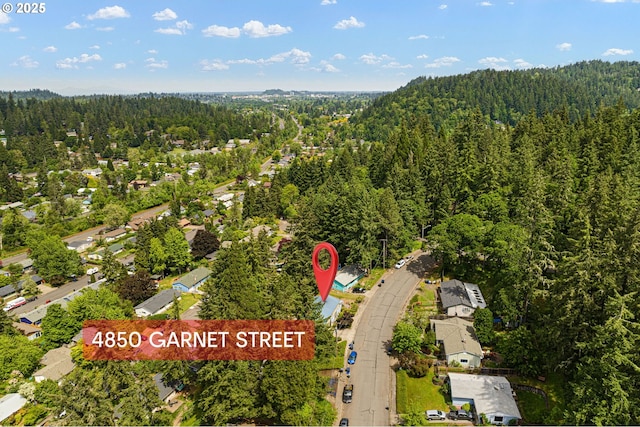 aerial view of property's location with a heavily wooded area