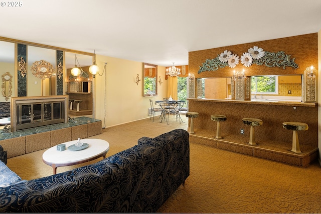 carpeted living area featuring healthy amount of natural light and a chandelier
