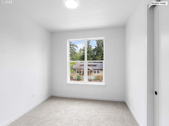 carpeted spare room featuring baseboards