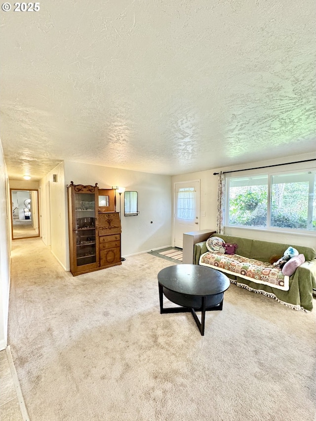 carpeted living room with baseboards and a textured ceiling