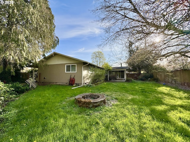 view of yard with a fire pit and fence