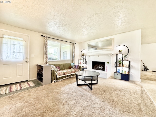 carpeted living area featuring a textured ceiling and a fireplace with raised hearth