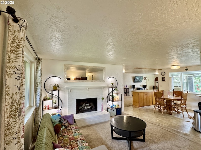 living room featuring a textured ceiling and a brick fireplace