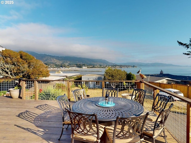 wooden deck with a water and mountain view