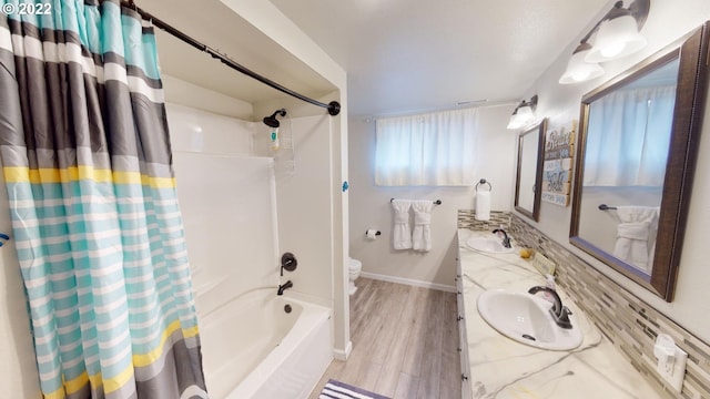 full bathroom featuring vanity, tasteful backsplash, hardwood / wood-style flooring, toilet, and shower / bath combo with shower curtain