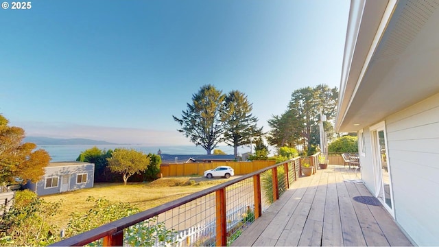 deck at dusk featuring a yard and an outbuilding