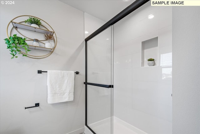 bathroom featuring a shower with door