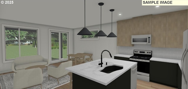 kitchen featuring pendant lighting, stainless steel range with electric cooktop, a center island with sink, sink, and tasteful backsplash