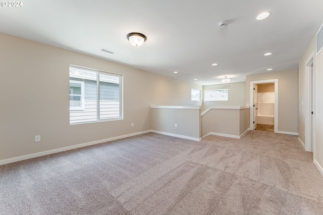 unfurnished room featuring light carpet and a healthy amount of sunlight