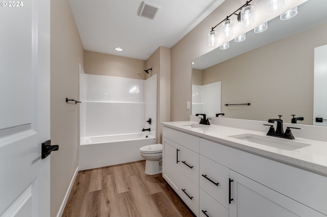 full bathroom featuring hardwood / wood-style floors, vanity, toilet, and shower / washtub combination