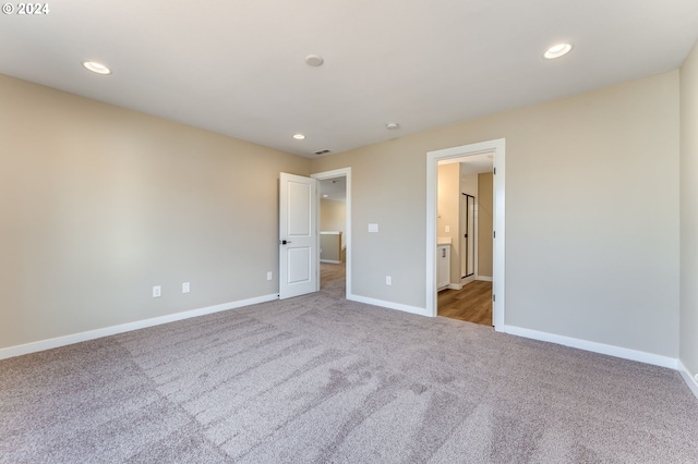 unfurnished bedroom featuring light carpet