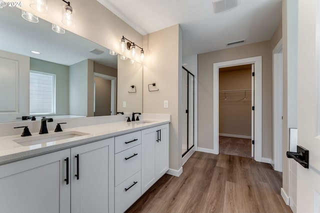 bathroom featuring hardwood / wood-style floors, vanity, and a shower with door