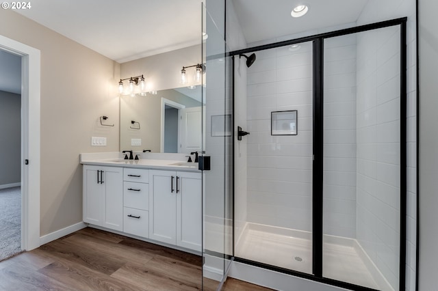 bathroom featuring walk in shower, vanity, and hardwood / wood-style flooring