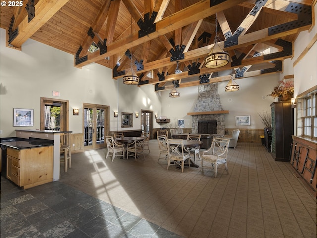 30605 E Camryn Way Unit D20, Government Camp, OR 97028 - dining area featuring high vaulted ceiling, a stone fireplace, a wainscoted wall, wooden ceiling with exposed beams, and french doors