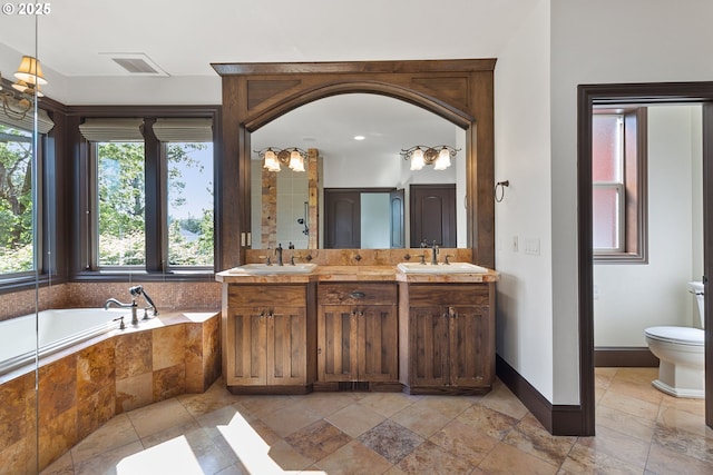 632 W T St, Washougal, WA 98671 - full bath featuring double vanity, a garden tub, toilet, baseboards, and stone tile floors