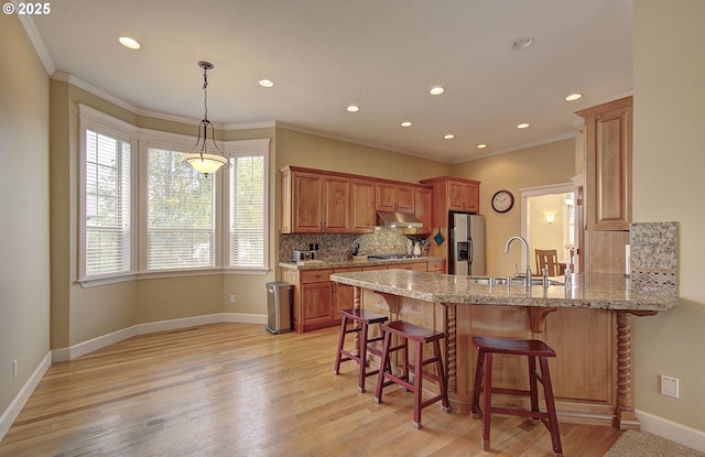 3313 NW Sierra Dr, Camas, WA 98607 - kitchen with stainless steel appliances, under cabinet range hood, a sink, a peninsula, and decorative backsplash