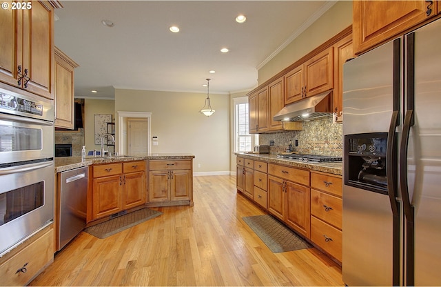 3313 NW Sierra Dr, Camas, WA 98607 - kitchen featuring appliances with stainless steel finishes, a sink, under cabinet range hood, ornamental molding, and a peninsula