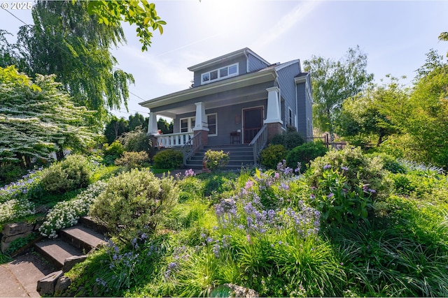 bungalow-style house with stairs and covered porch