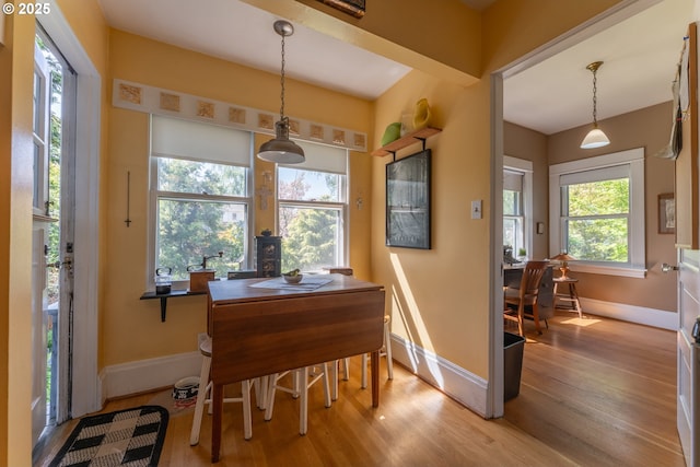 dining area with baseboards and wood finished floors