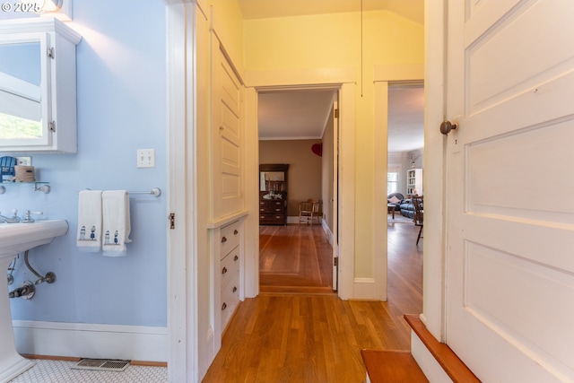 bathroom with baseboards, wood finished floors, and visible vents