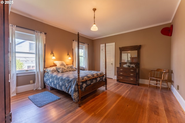 bedroom featuring wood-type flooring, baseboards, and ornamental molding