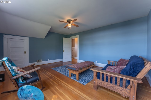 living room featuring baseboards, ceiling fan, visible vents, and wood finished floors